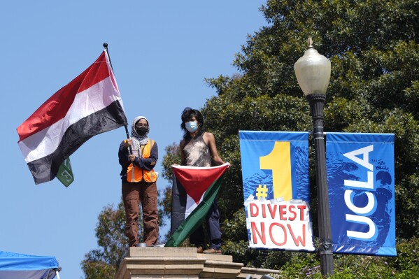 Demonstrators wave flags on the UCLA campus, after nighttime clashes between Pro-Israel and Pro-Palestinian groups, Wednesday, May 1, 2024, in Los Angeles. (AP Photo/Jae C. Hong)